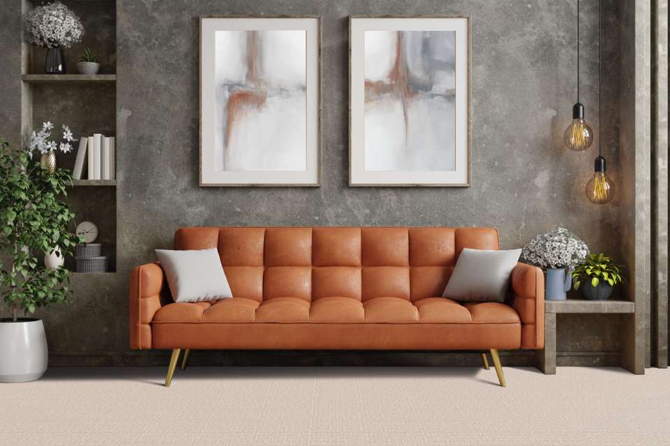 beige patterned carpet in retro style living room with leather couch and grey washed accent wall